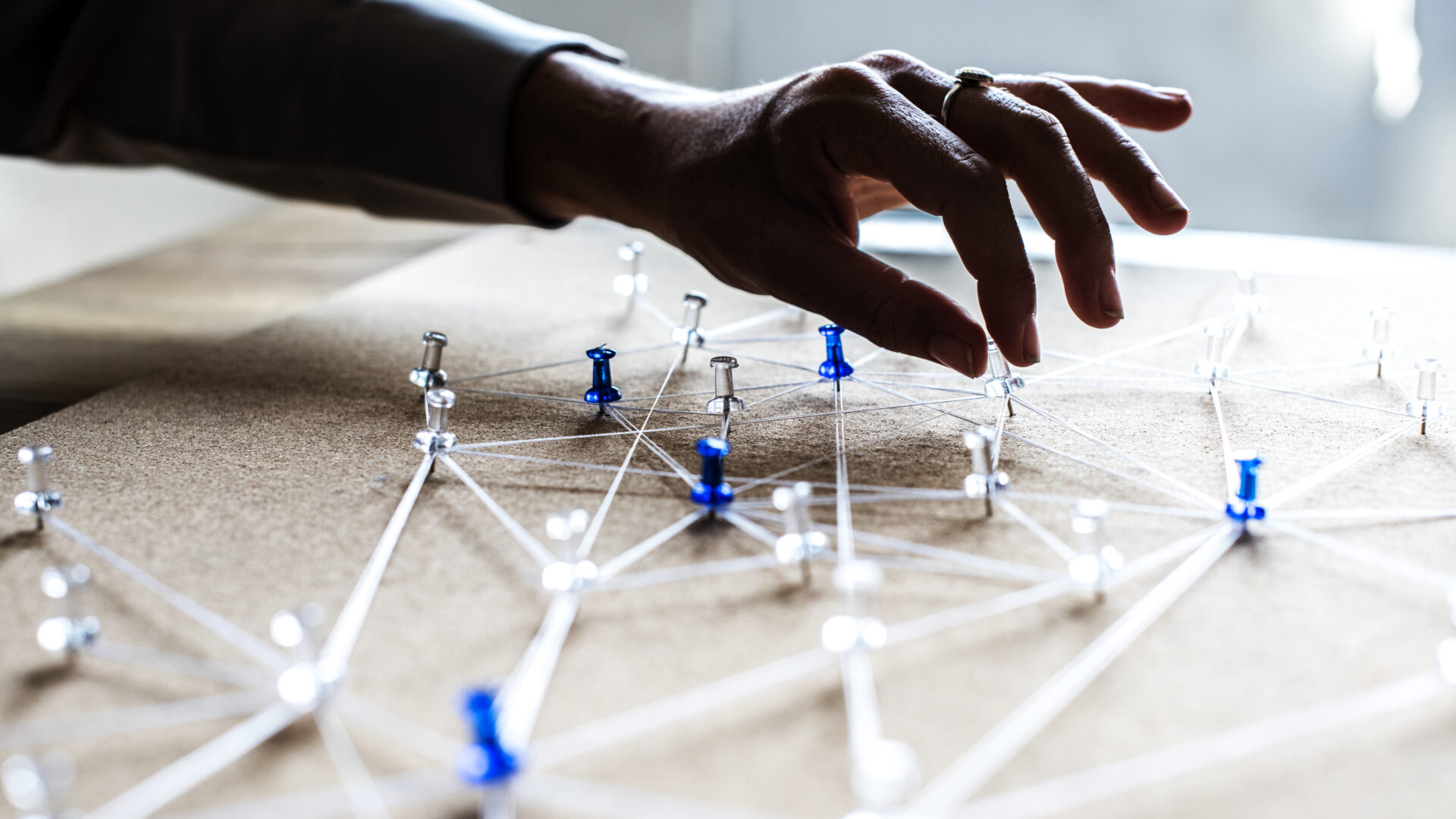 Board with strings tied around push pins